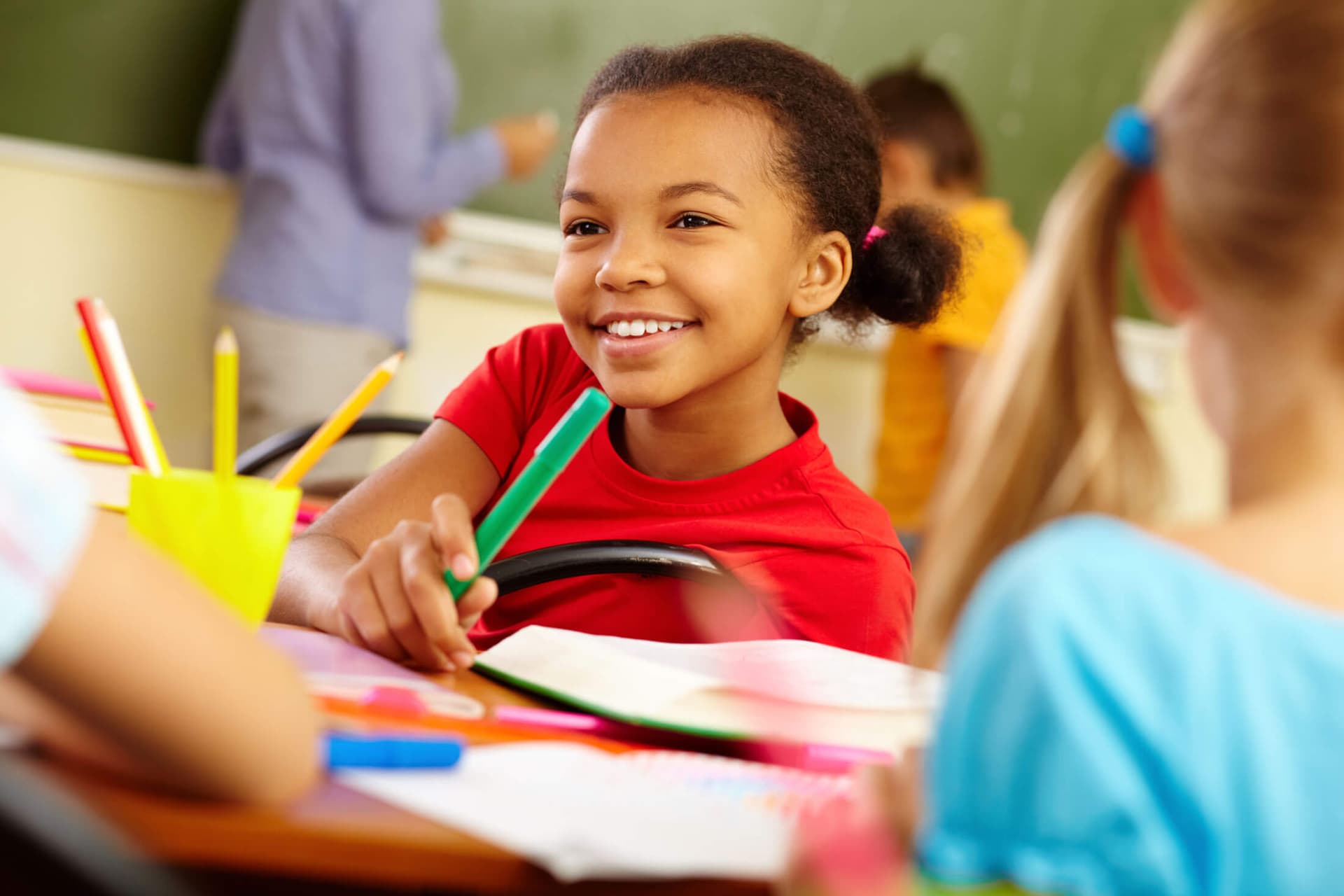 A child smiling while working in a Montessori classroom