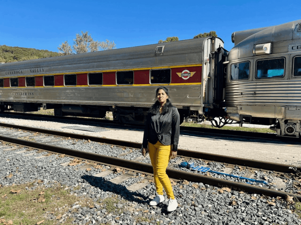Ms. Veda standing beside a Cuyahoga Valley train