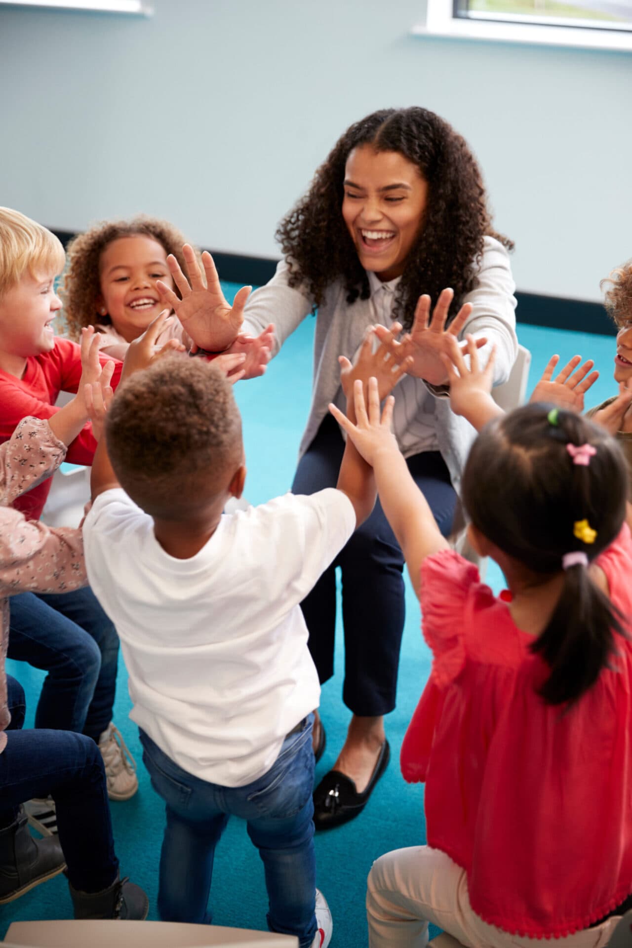 A Creative Playrooms teacher reading with children