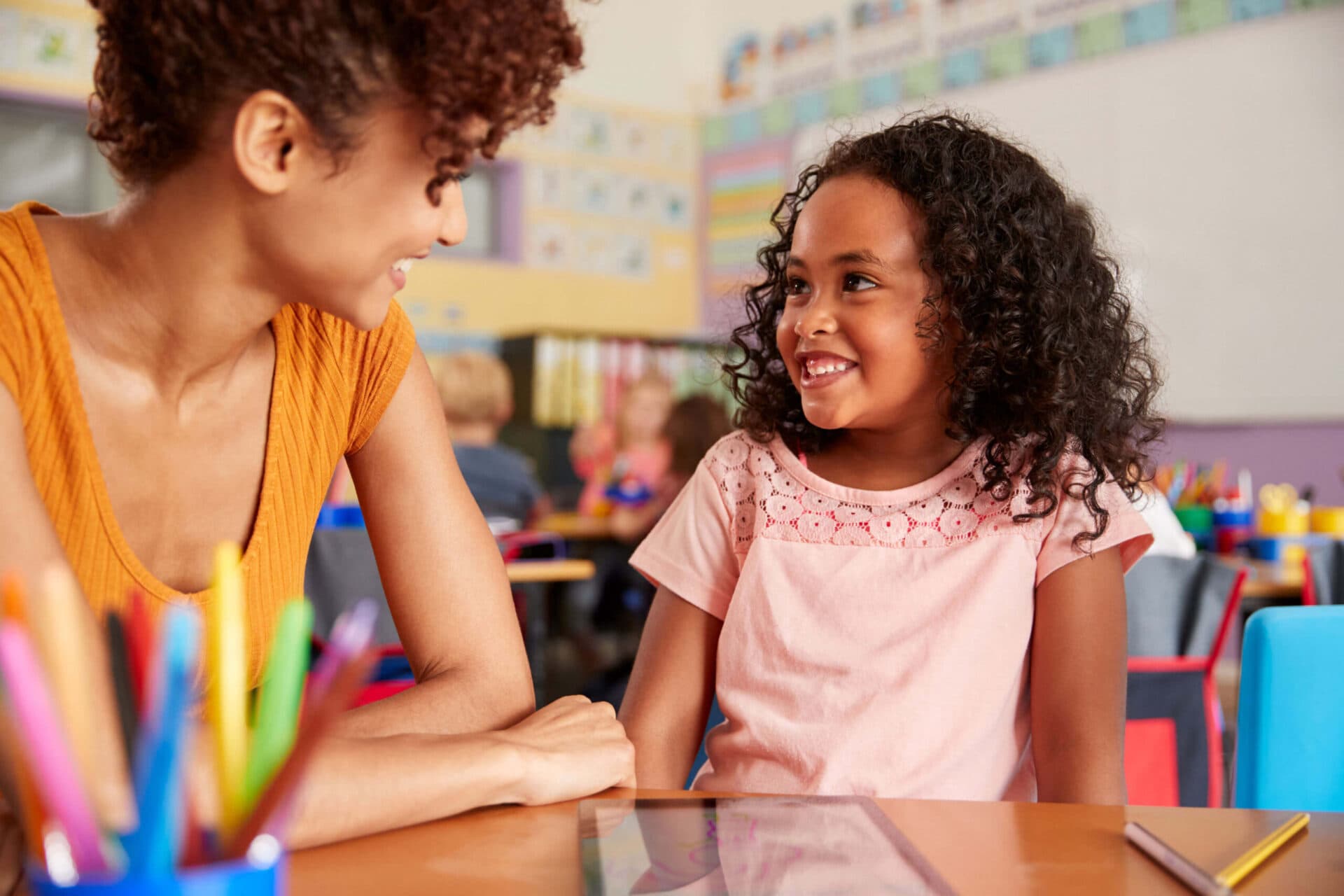 A teacher and a child smiling at each other in a Creative Playrooms classroom