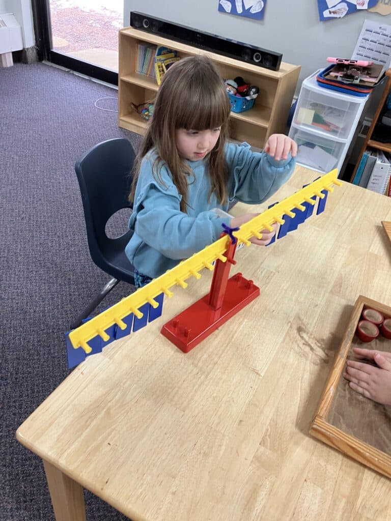 Child using a balance activity in a Montessori classroom